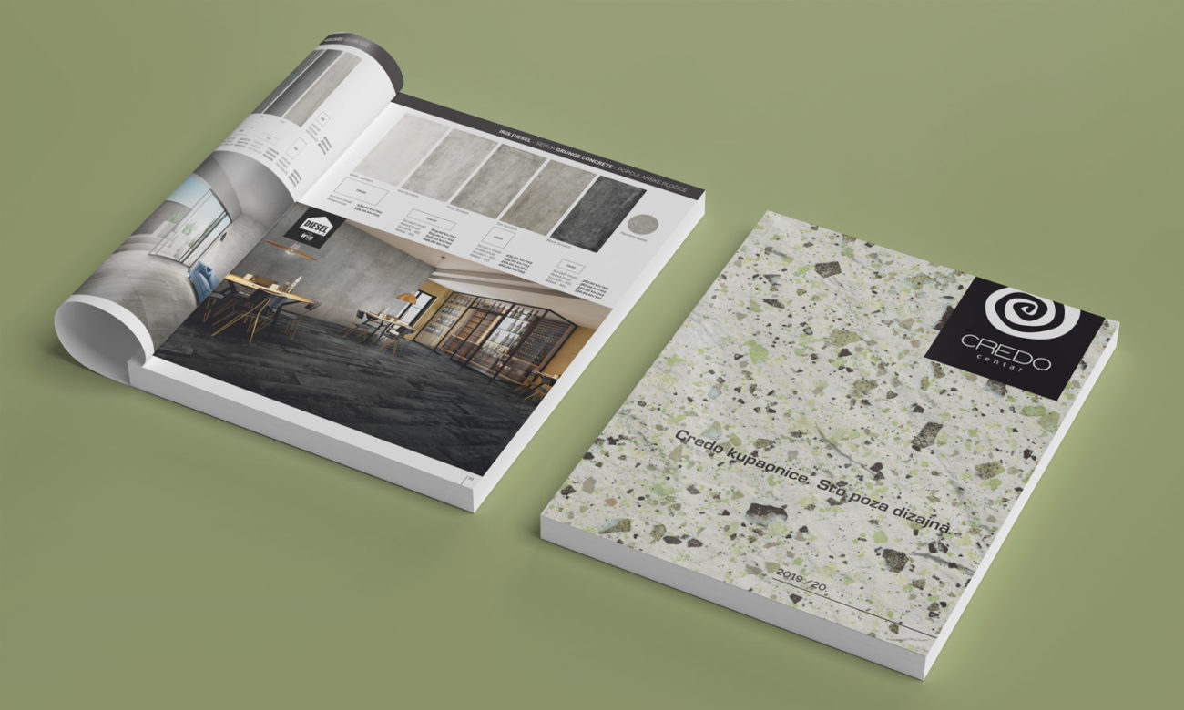 Na slici se nalazi Credo katalog na maslinasto zelenoj podlozi. jedan je zatvoren pa se vidi naslovnica koja je bijela sa crnim tekstom te jedan otvoren katalog.