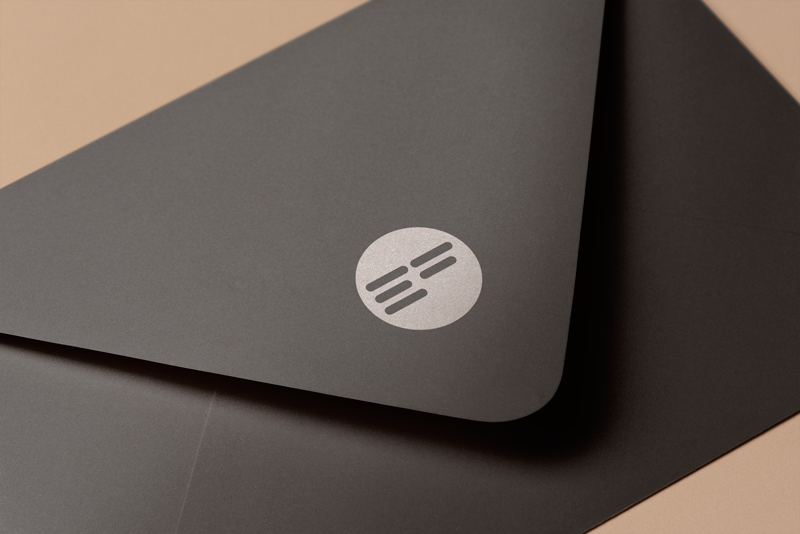 Aplikacija loga Error Free na kuvertu. Na slici je prikazana crna kuverta sa otisnutom ikonom loga.